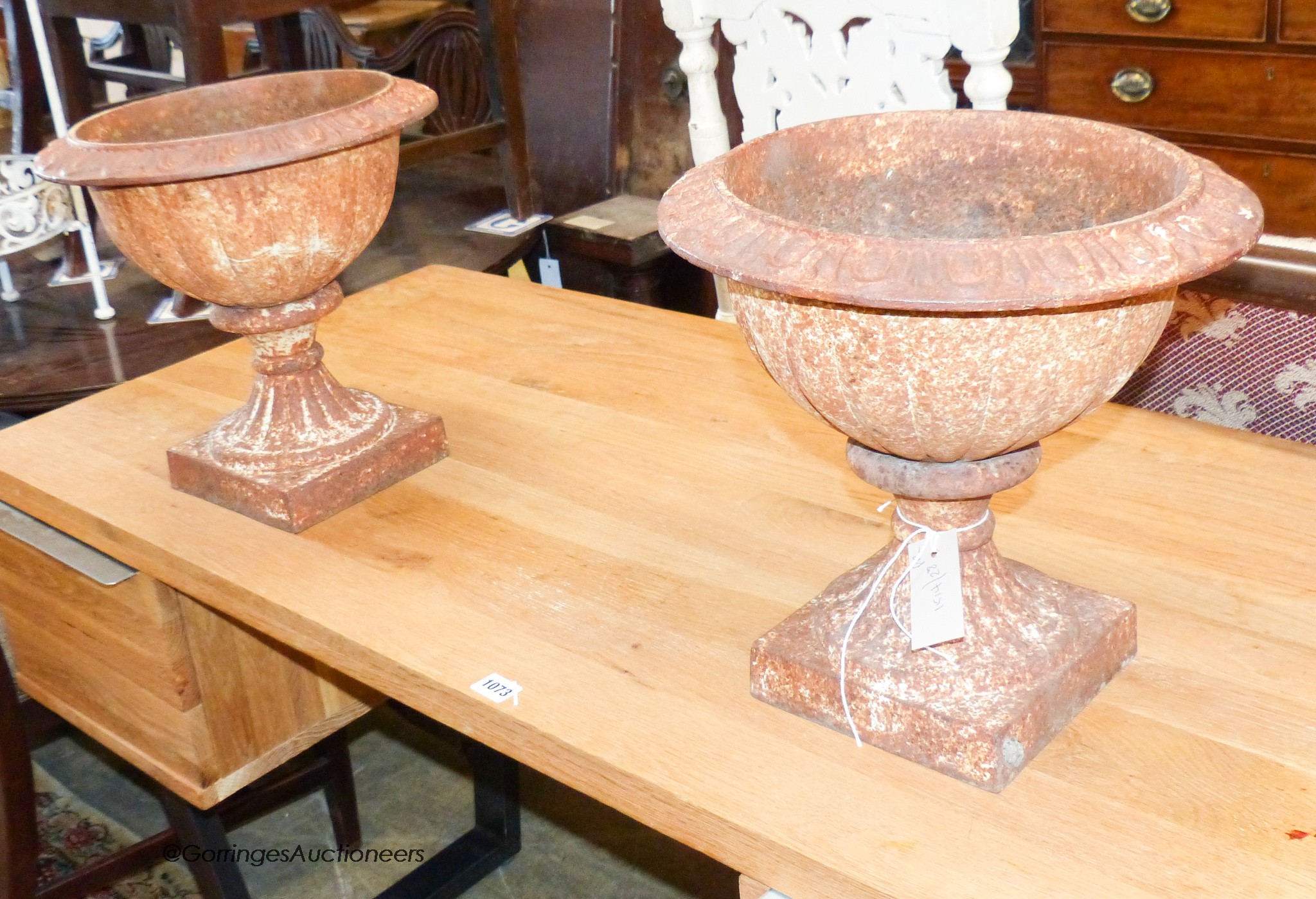 A pair of circular cast iron campana shaped garden urns, 34cm diameter, height 34cm